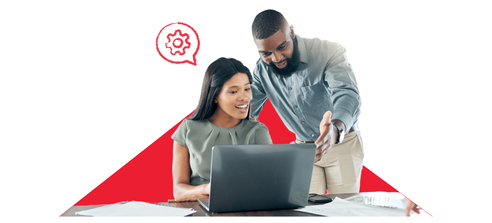 A colleague sits at a desk, with a manager supporting them.